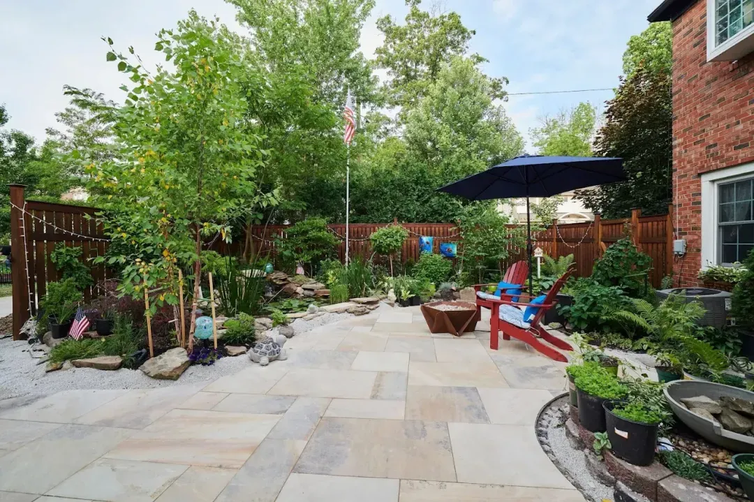 Flagstone patio with a fire bowl, umbrella and water feature